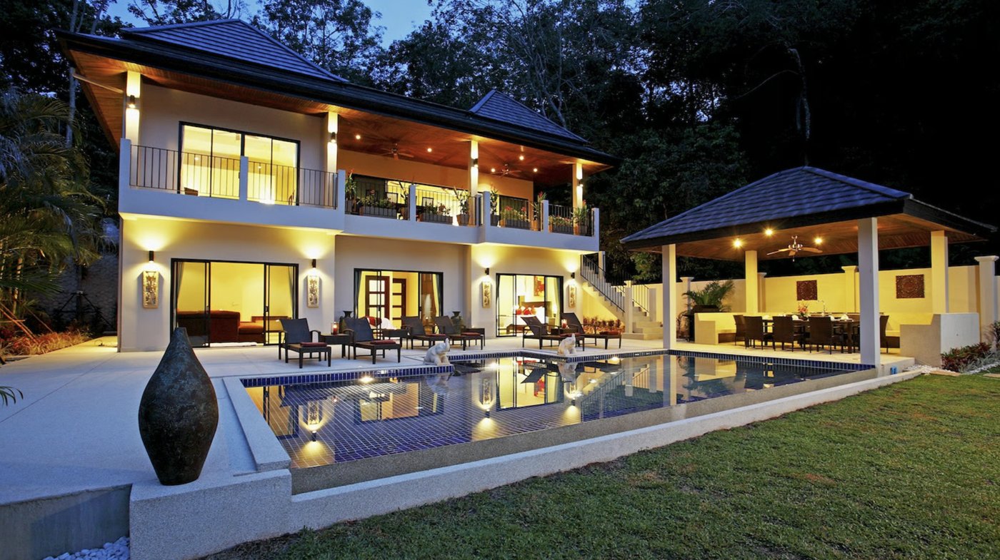 The private villa and pool lit up at dusk